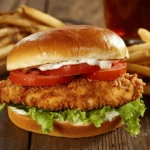 Golden crispy chicken cutlet sandwich with fries and iced tea.